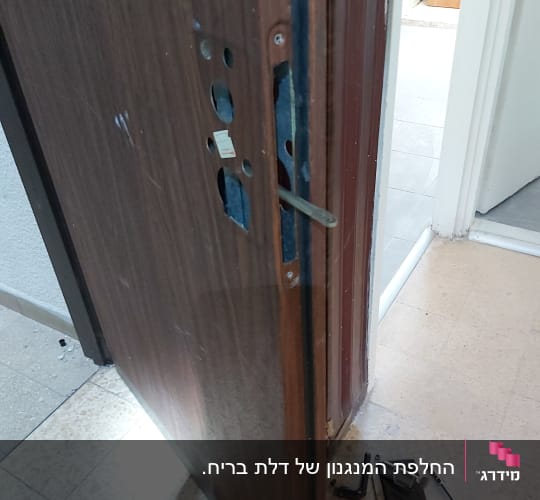 דלת פתוחה עם מנעול מפורק וכלי עבודה על הרצפה